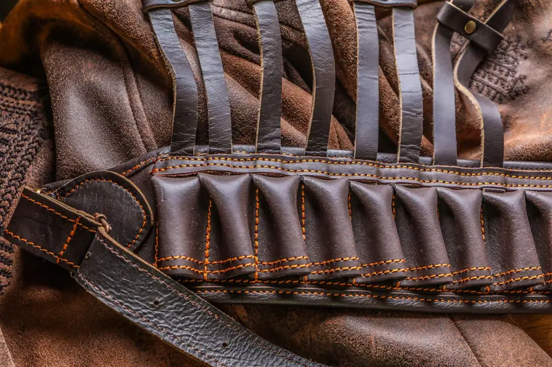 Detailed closeup of a brown leather ammo belt on a textured leather jacket