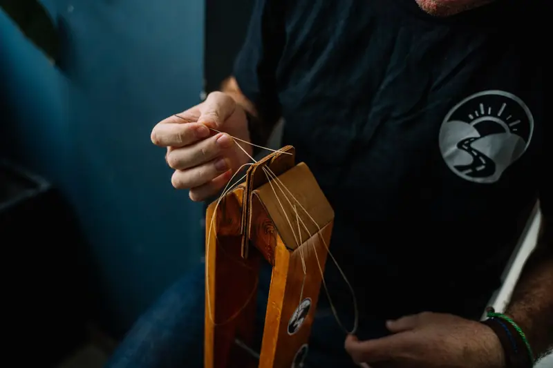 Artisan skillfully stitching a leather wallet using traditional hand tools