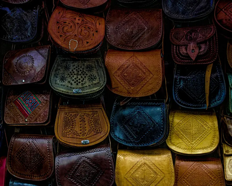 A vibrant collection of handcrafted Moroccan leather bags, showcasing unique patterns and designs